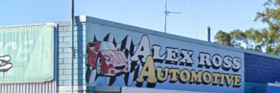 The Alex Ross Automotive sign, with its hot rod and chequered flag mark, on the second workshop building at Weston